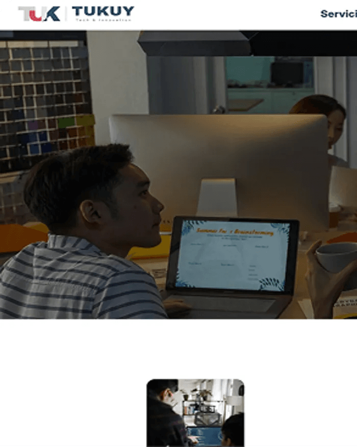 captura de pantalla del sitio web de tukuylabs donde se ve a una persona sentada frente a una laptop en lo que parece ser una reunion